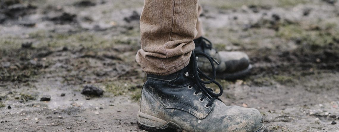 workman wearing boots in muddy autumn winter